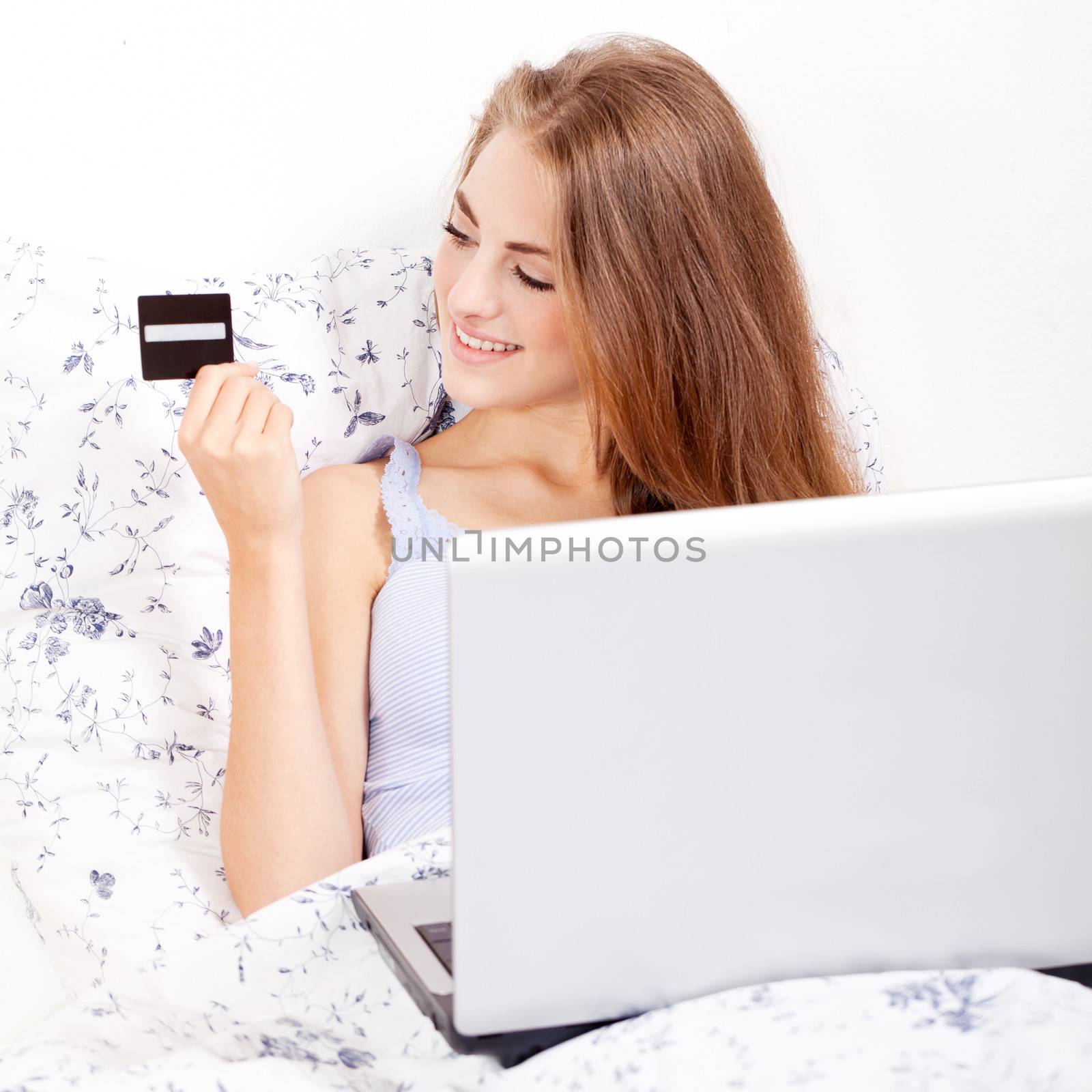 girl sitting in bed and shopping online with credit card onlineshop ecommerce