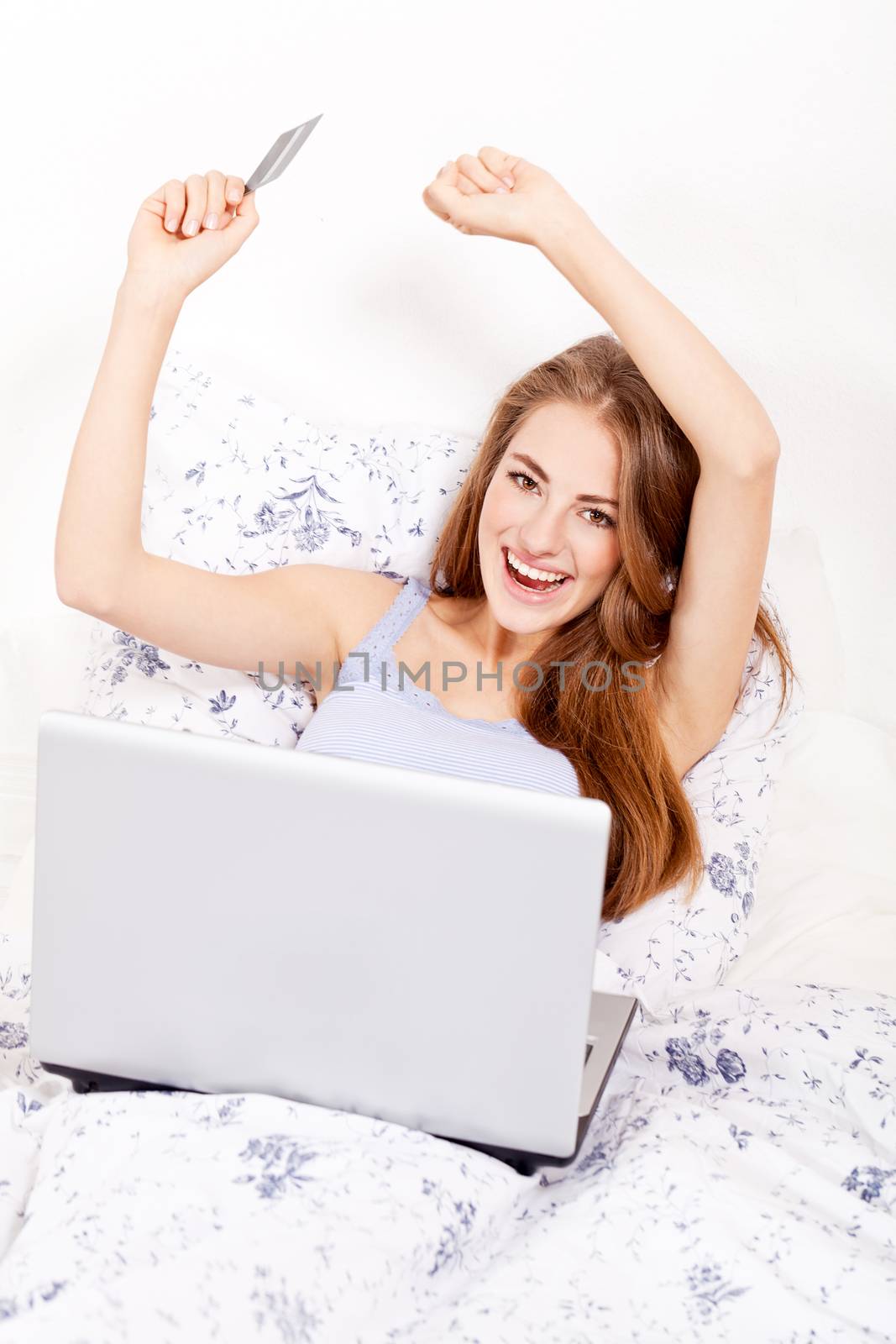 girl sitting in bed and shopping online with credit card onlineshop ecommerce