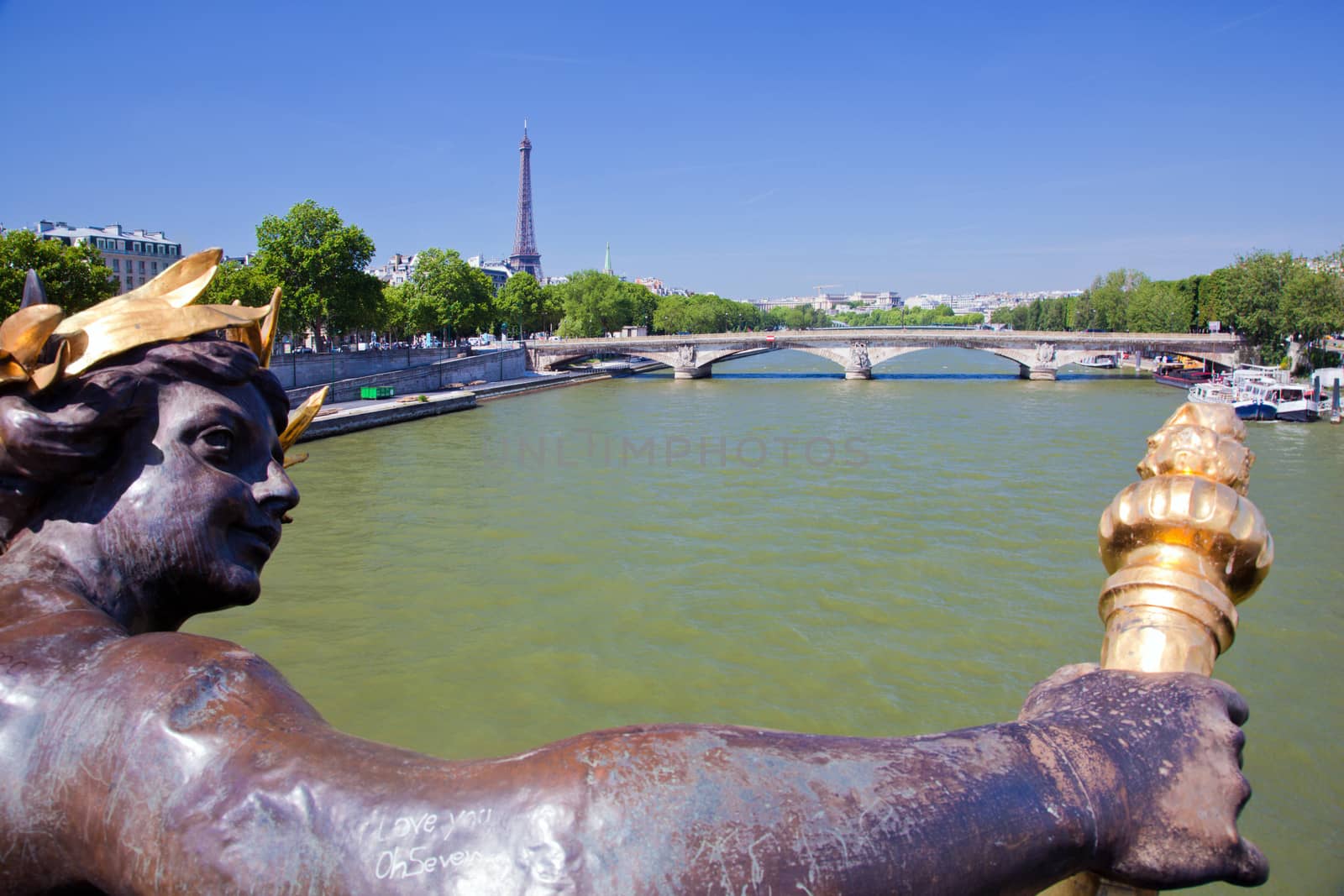 Eiffel Tower and bridge on Seine river in Paris, France. Artistic statue on Alexandre Bridge