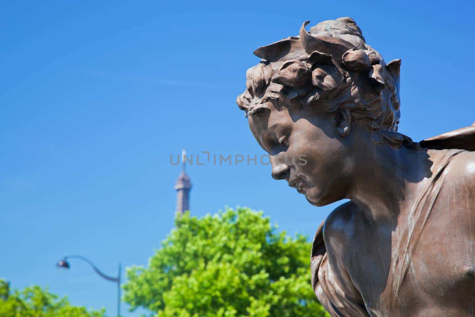 Artistic statue on Alexandre Bridge conceptually looking at Eiffel Tower, Paris, France.