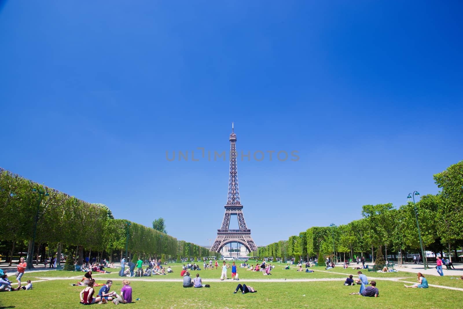 PARIS - JUNE 7 :Tourists and locals take advantage of sunny summer weather on Champ de Mars next to the Eiffel Tower on June 7, 2013, Paris, France