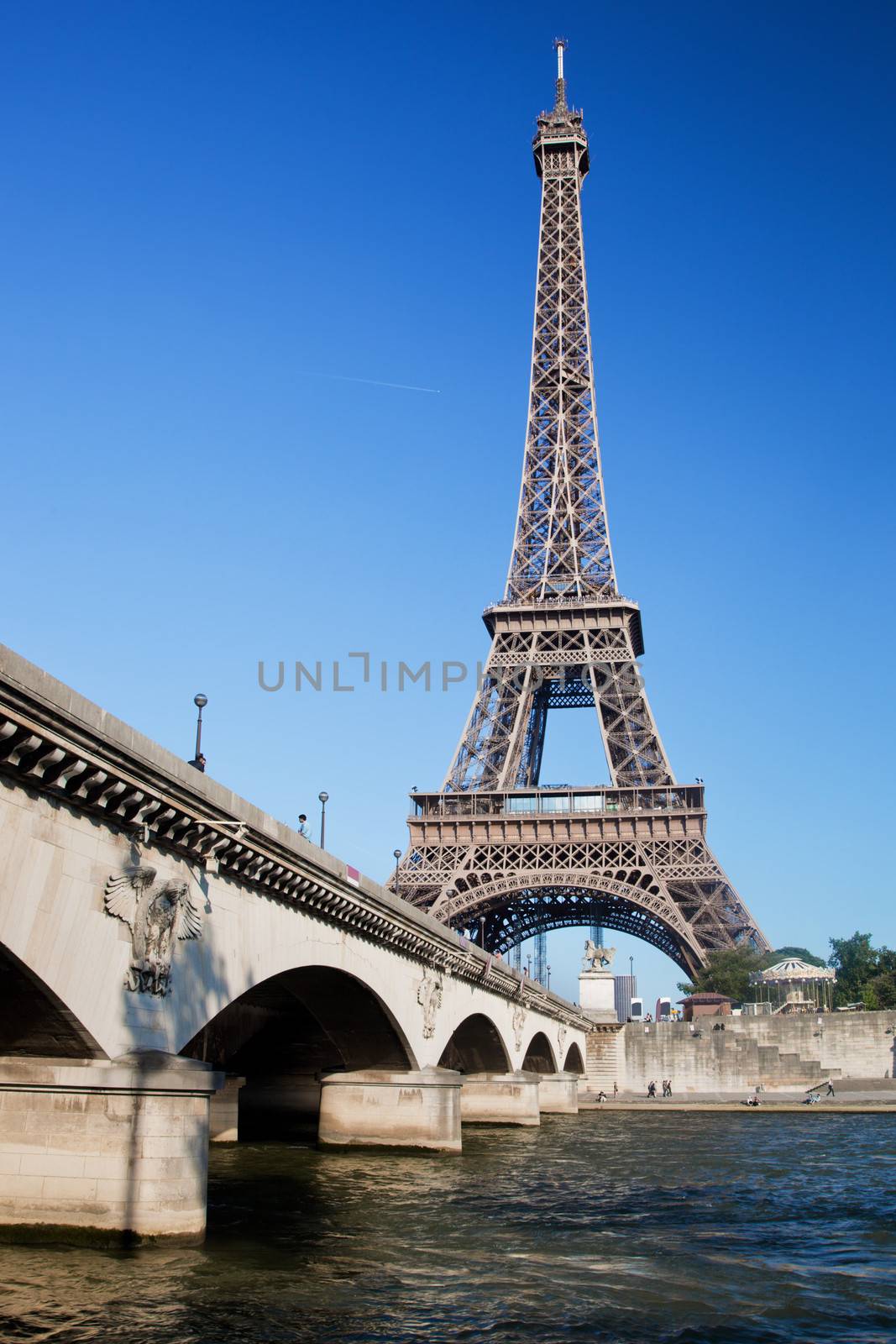Eiffel Tower and bridge on Seine river in Paris, France at a sunny day