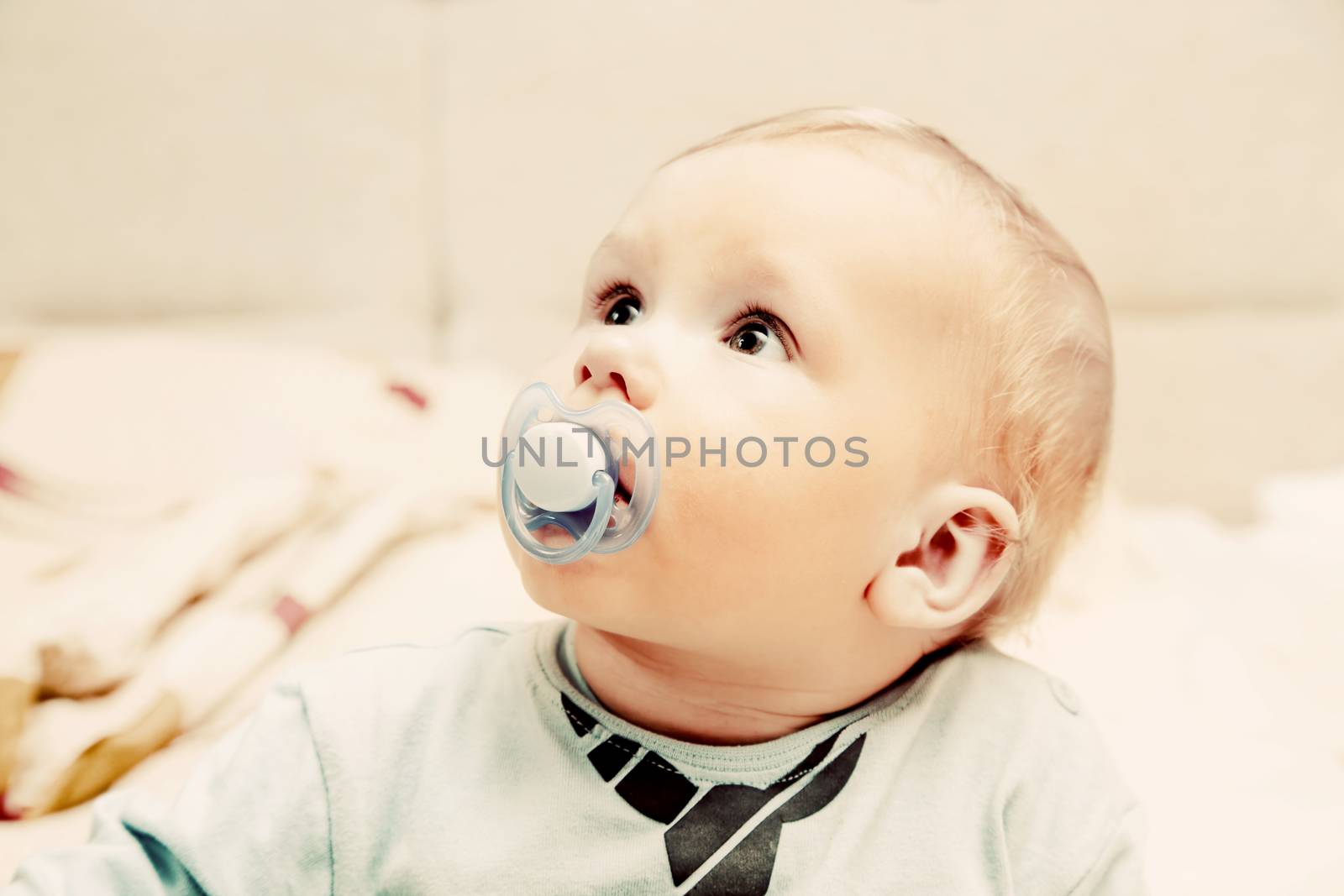 Young baby boy with a dummy in his mouth portrait by photocreo