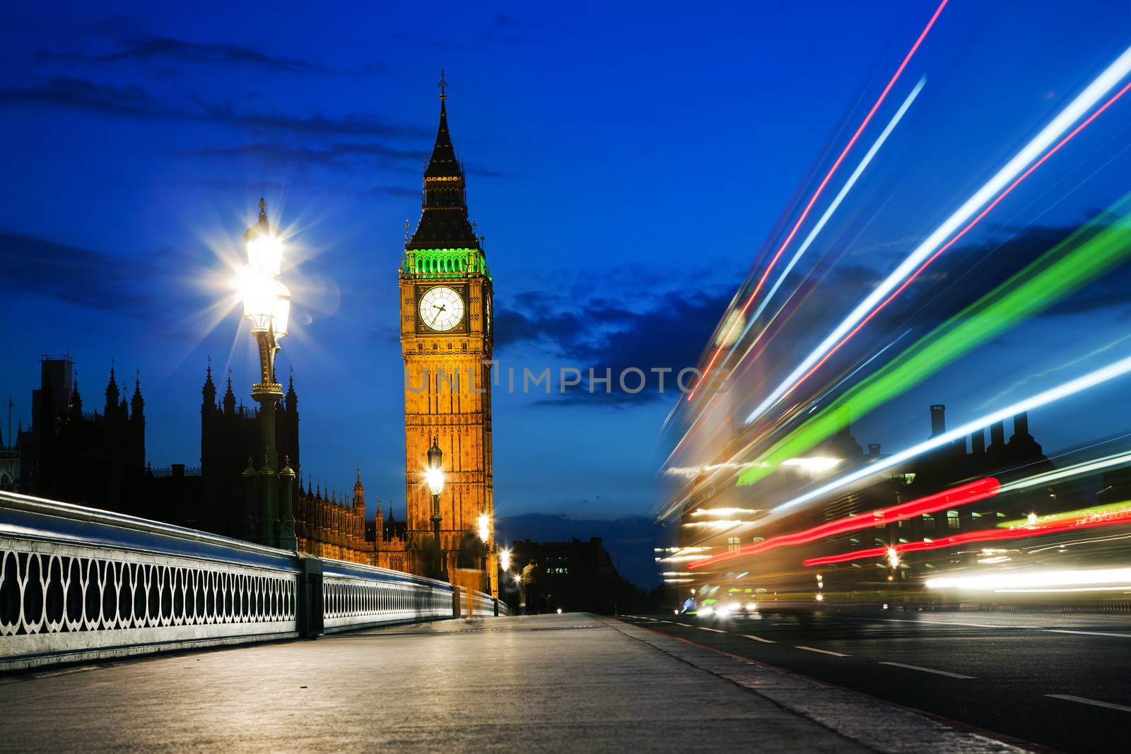 London, the UK. Red bus in motion and Big Ben, the Palace of Westminster at night. The icons of England