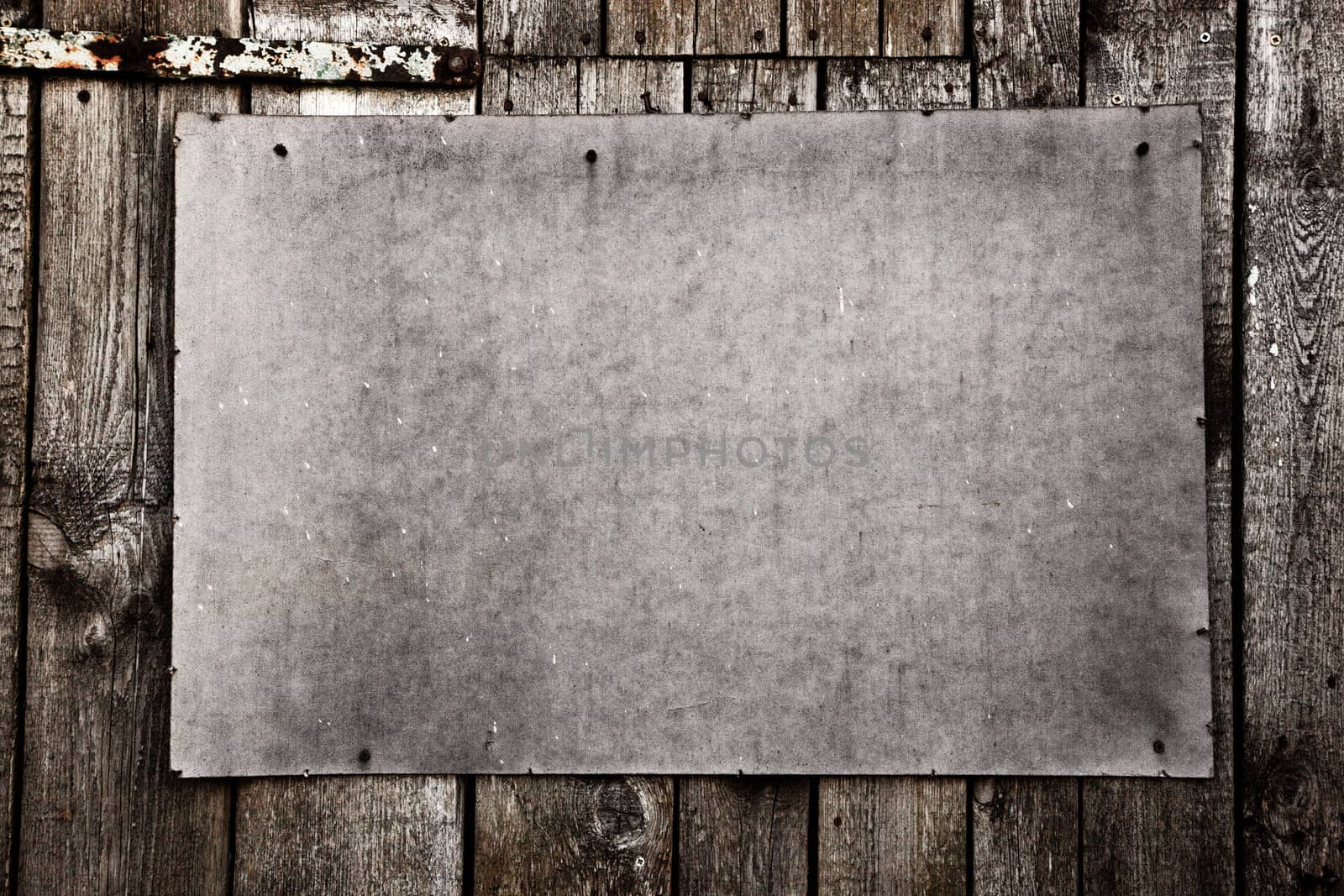 Old grunge plywood board on a wooden wall. Scratched and rusty. Good for background, texture.