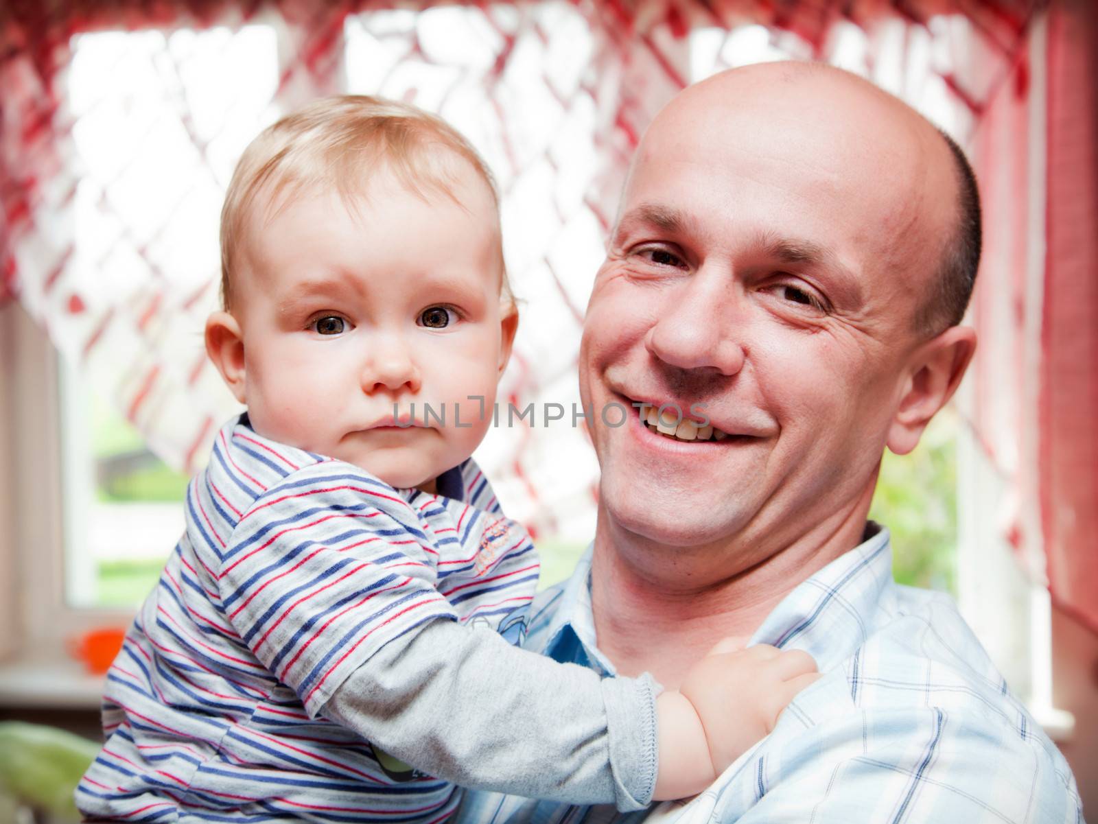 Father with his little baby son portrait in home. Happy, smiling.