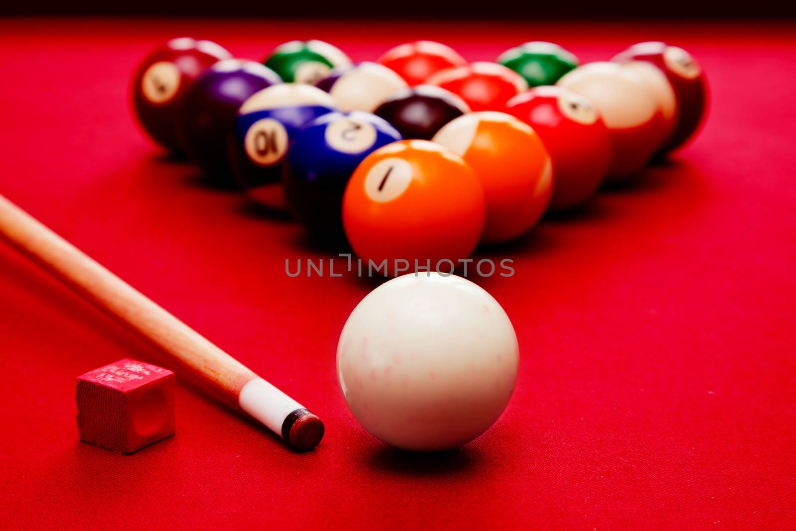 Billards pool game. Cue ball, cue, color balls in triangle, chalk. Red cloth table