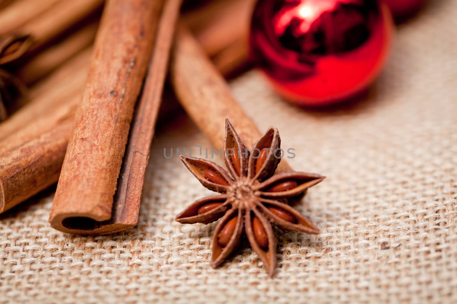 christmas decoration cinnamon anise baubles in red macro closeup