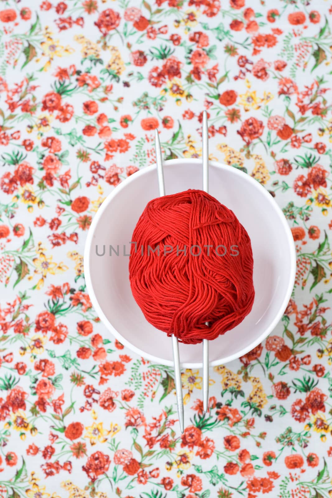 White plate, the spokes, red and white ball on the background of a red flower