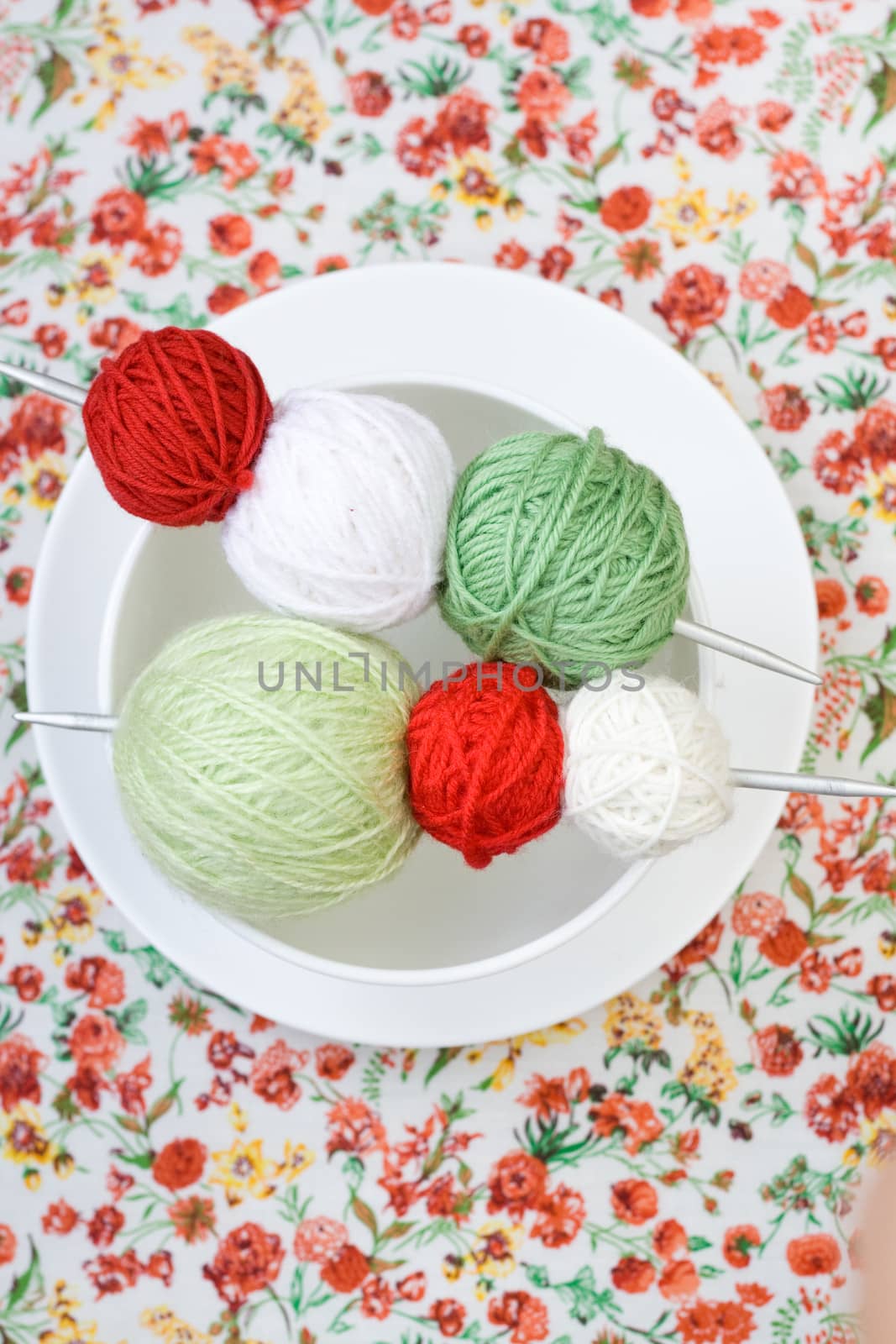 A lot of bright balls of knitting on the background of a red flower