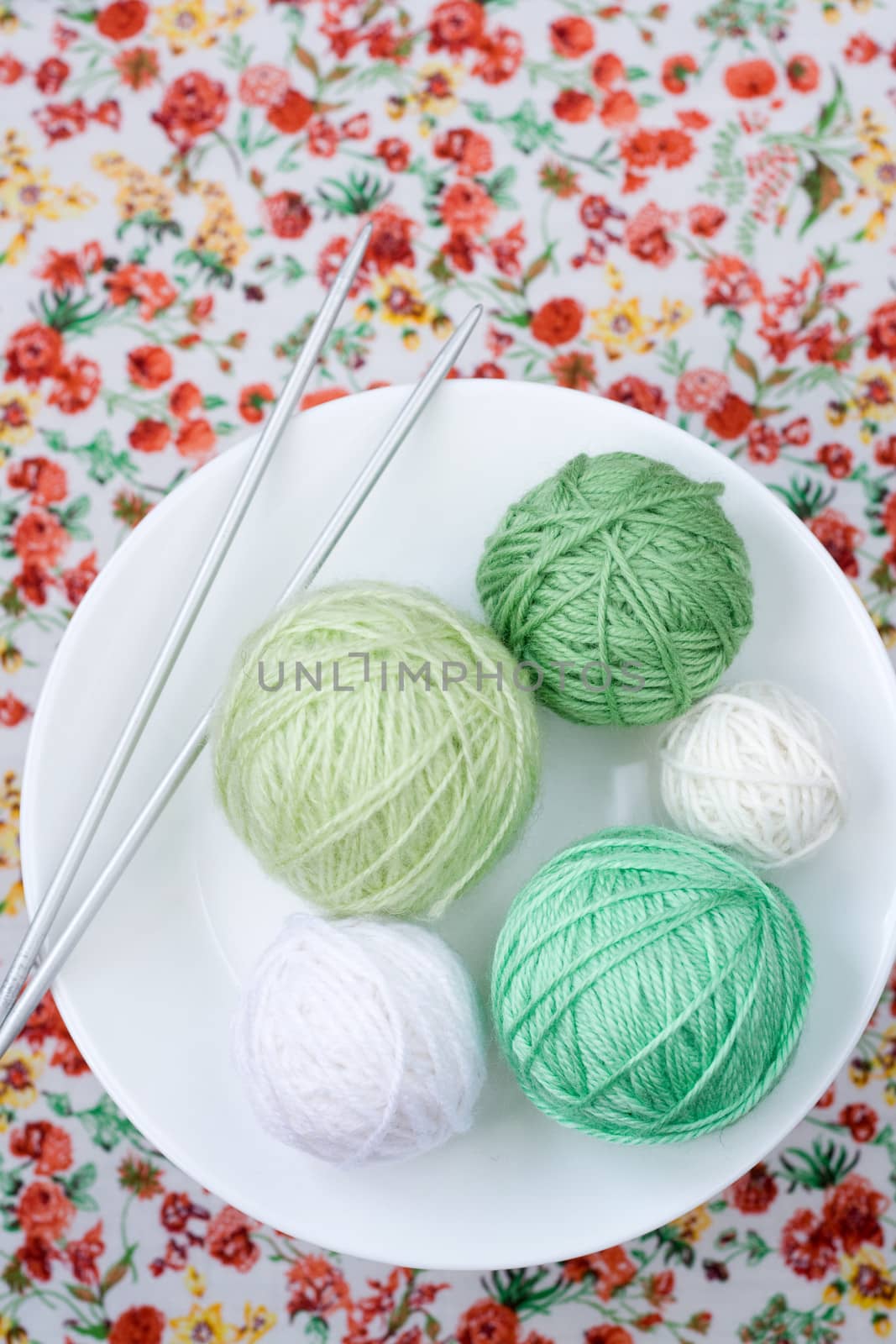 A lot of bright balls of knitting on the background of a red flower