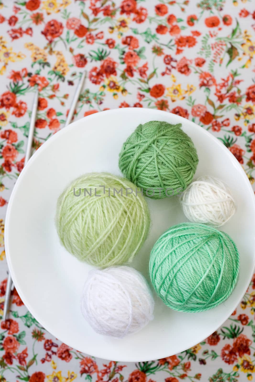 A lot of bright balls of knitting on the background of a red flower