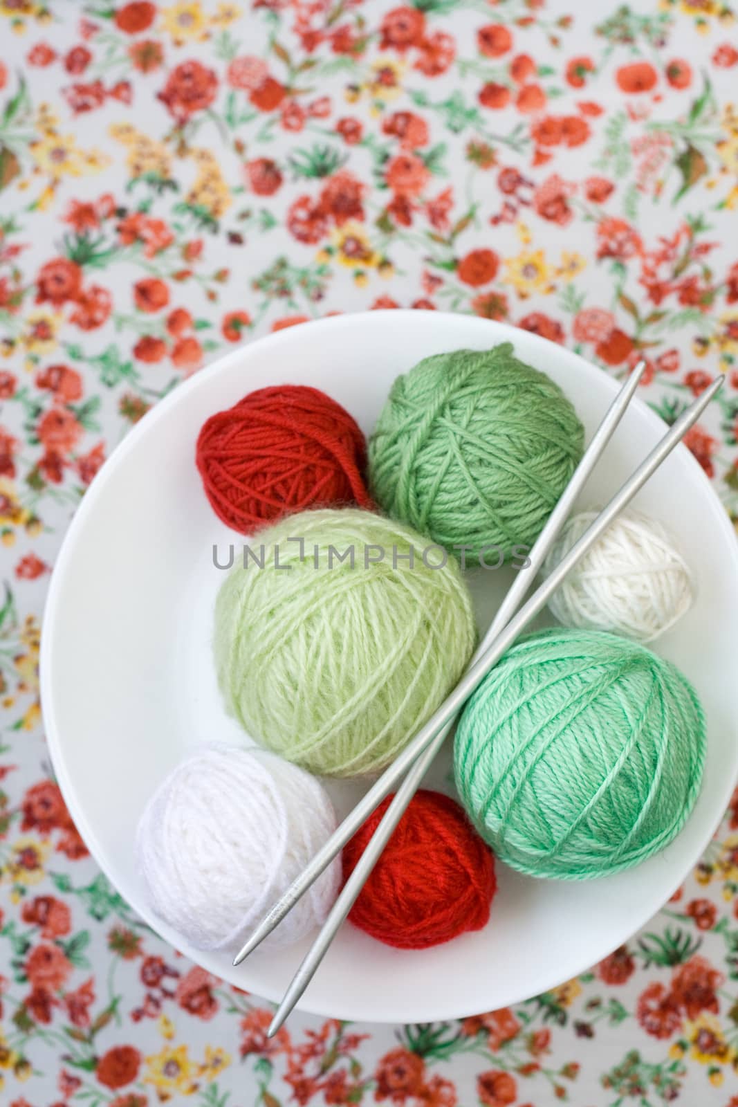 A lot of bright balls of knitting on the background of a red flower