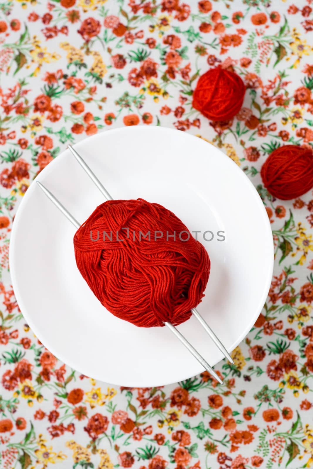 White plate, the spokes, red and white ball on the background of a red flower