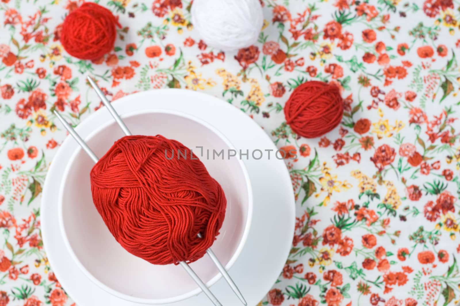 White plate, the spokes, red and white ball on the background of a red flower