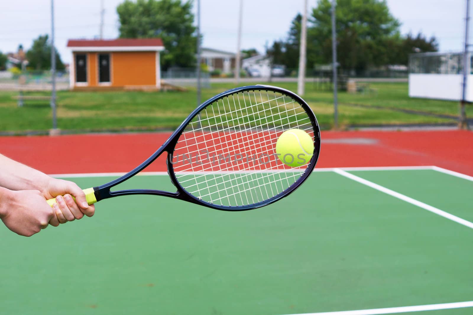 Player hands on tennis racket hitting a back hand volley