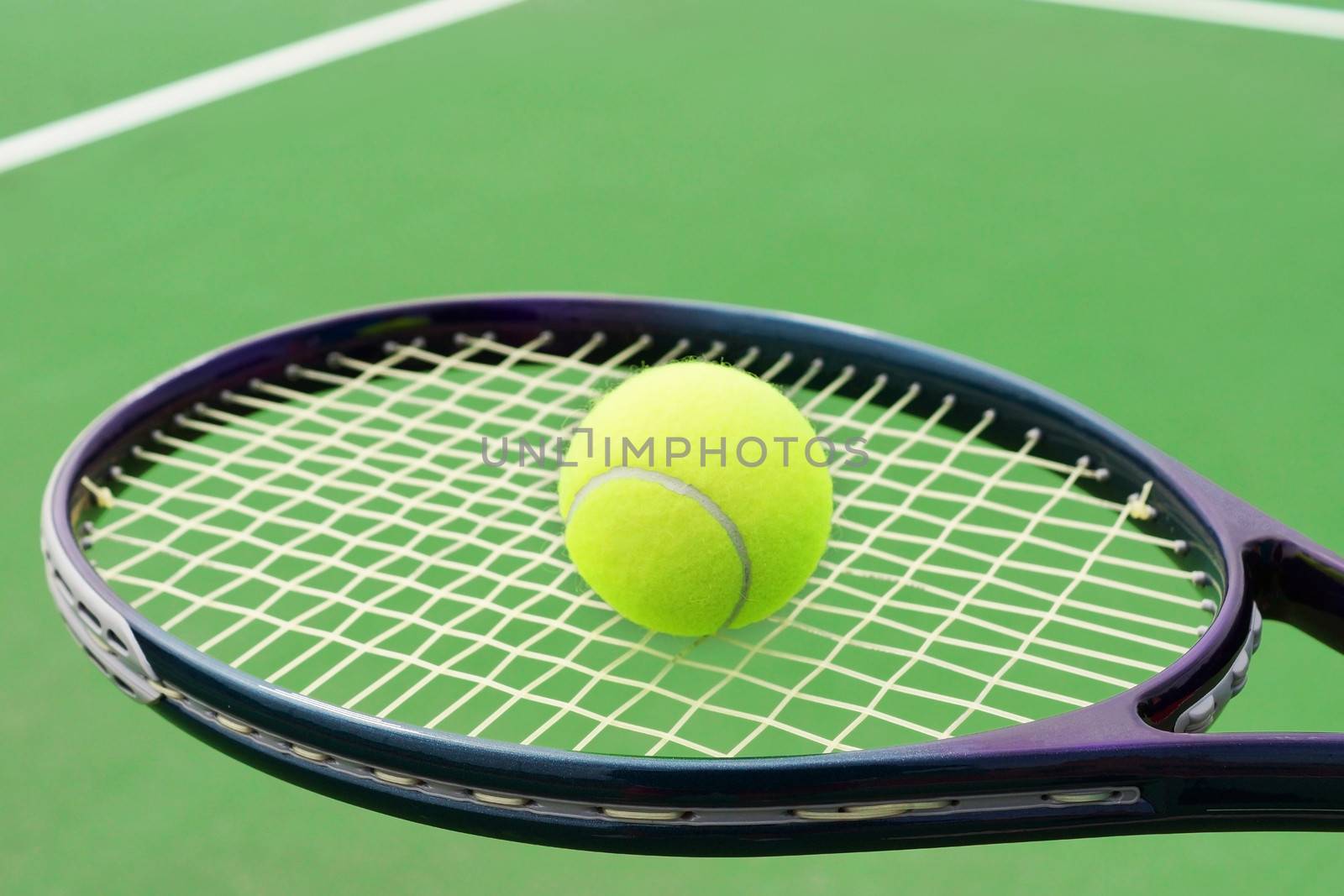 Tennis racket with ball on hard surface court