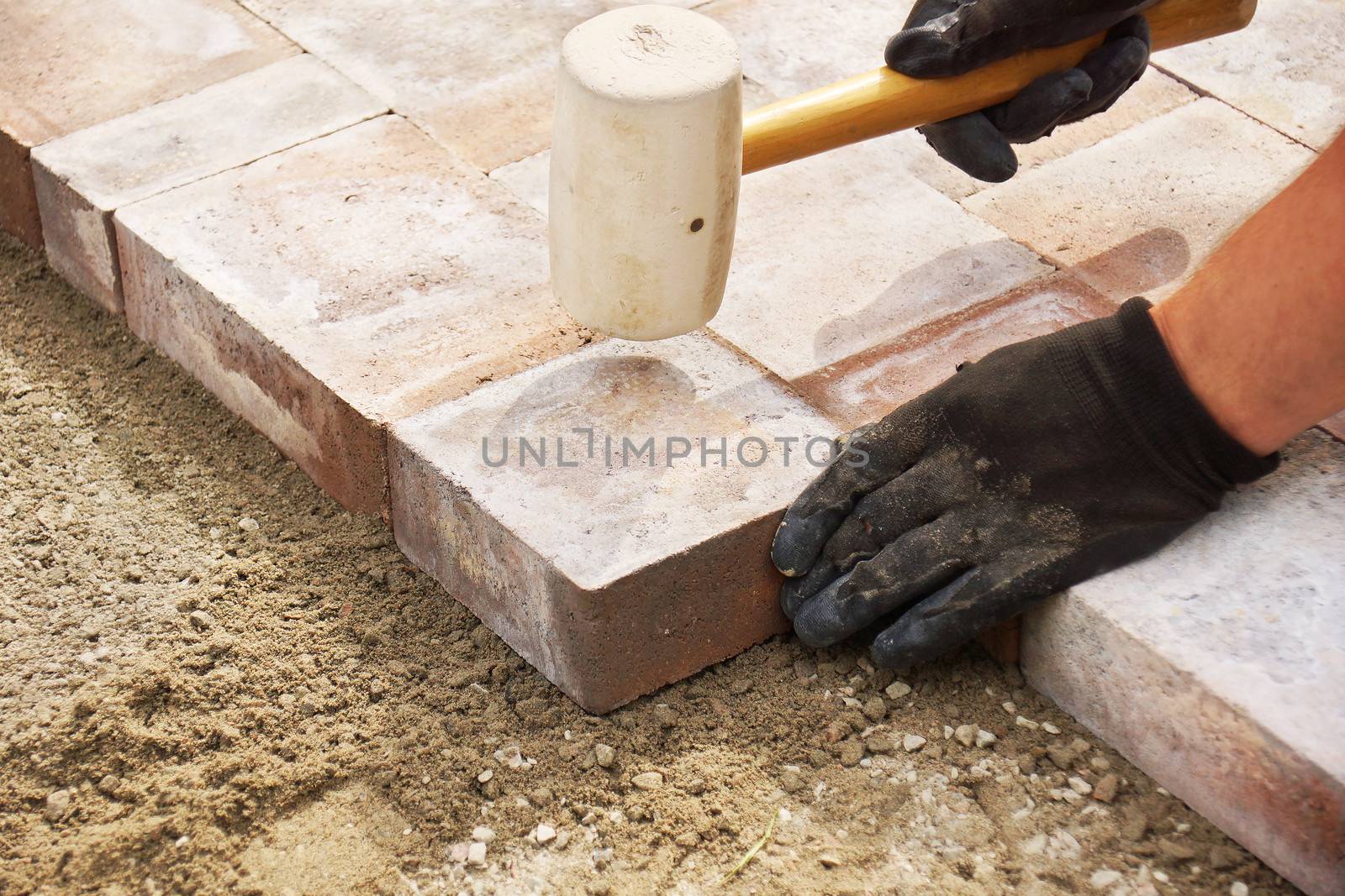 Installing paver bricks on patio, mallet to level the stones