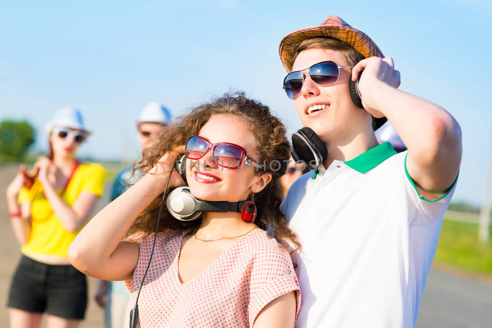 young couple standing on the road, having fun with friends