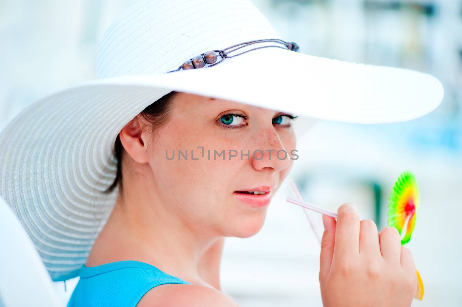 beautiful woman drinking a cocktail in a white hat