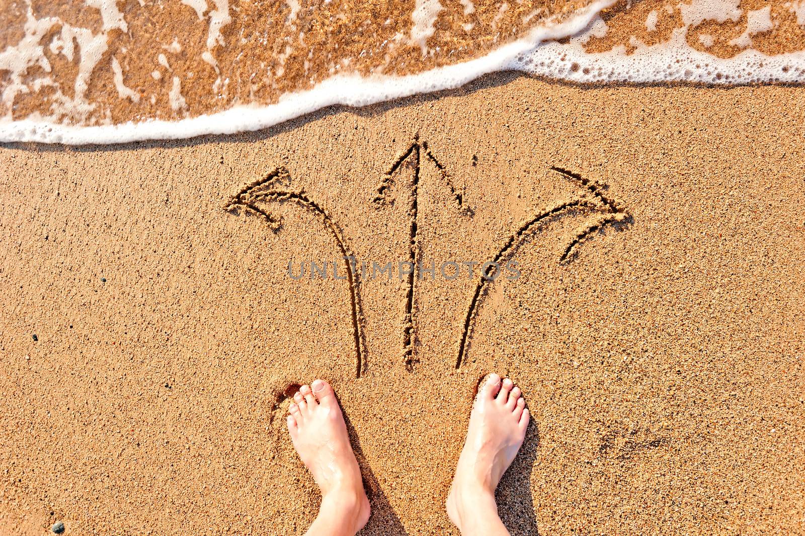 men's bare feet in the sand and arrows