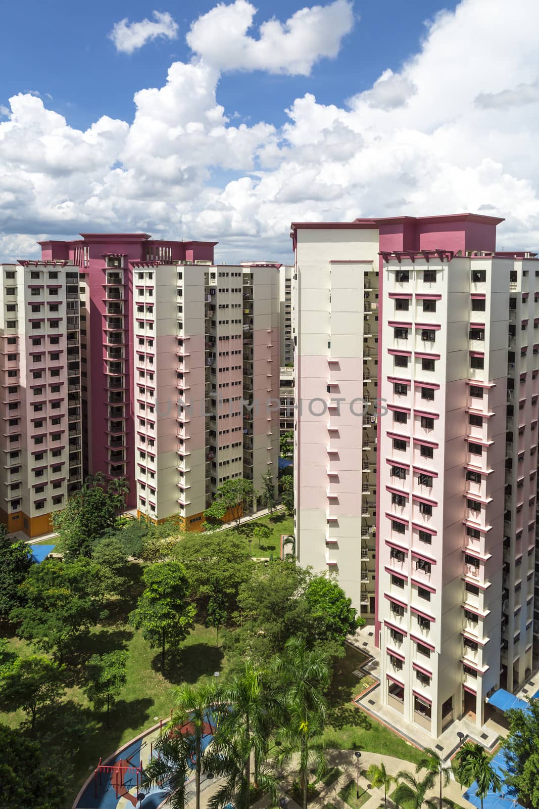 A vertical shot of a pink estate with park and playground.