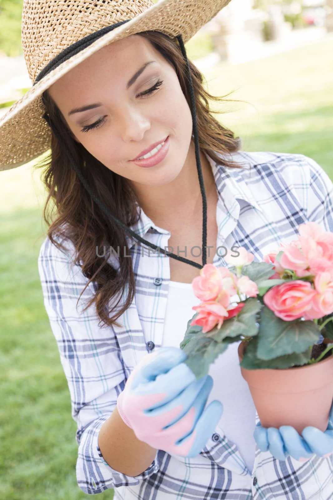 Young Adult Woman Wearing Hat Gardening Outdoors by Feverpitched