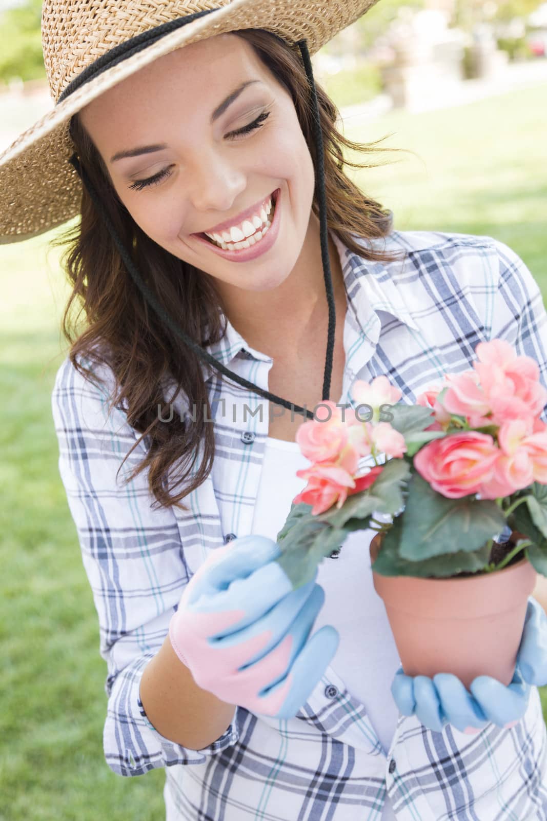 Young Adult Woman Wearing Hat Gardening Outdoors by Feverpitched