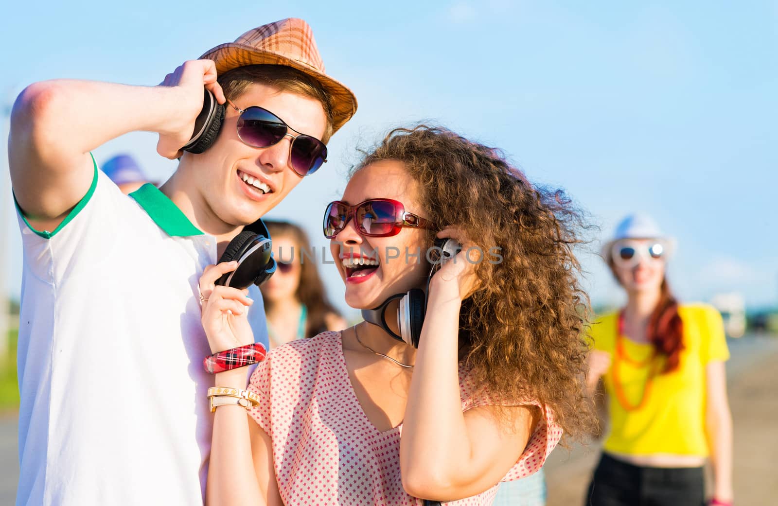 young couple standing on the road, having fun with friends