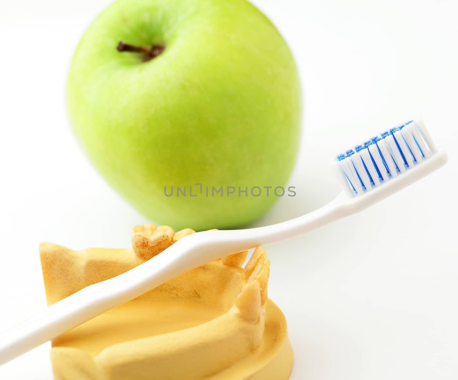 Dental health care concept, green apple and toothbrush