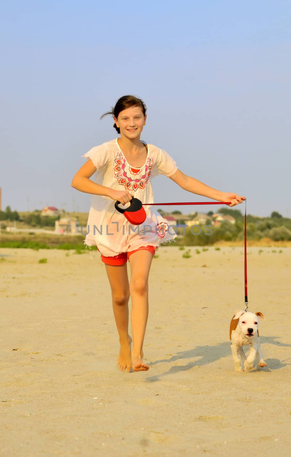girl running with her dog on the sand  by mady70