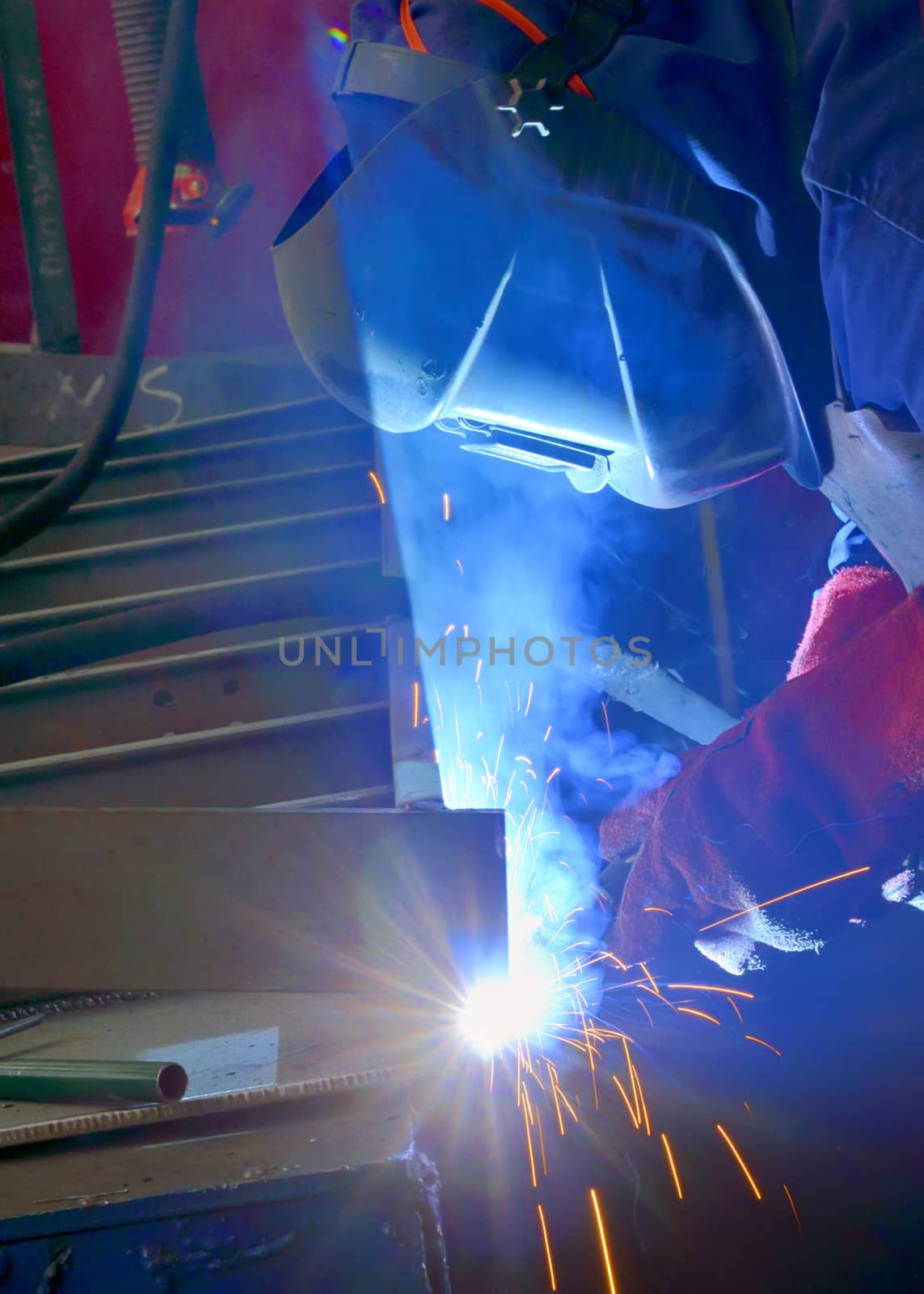 welder with protective mask welding metal and sparks by mady70