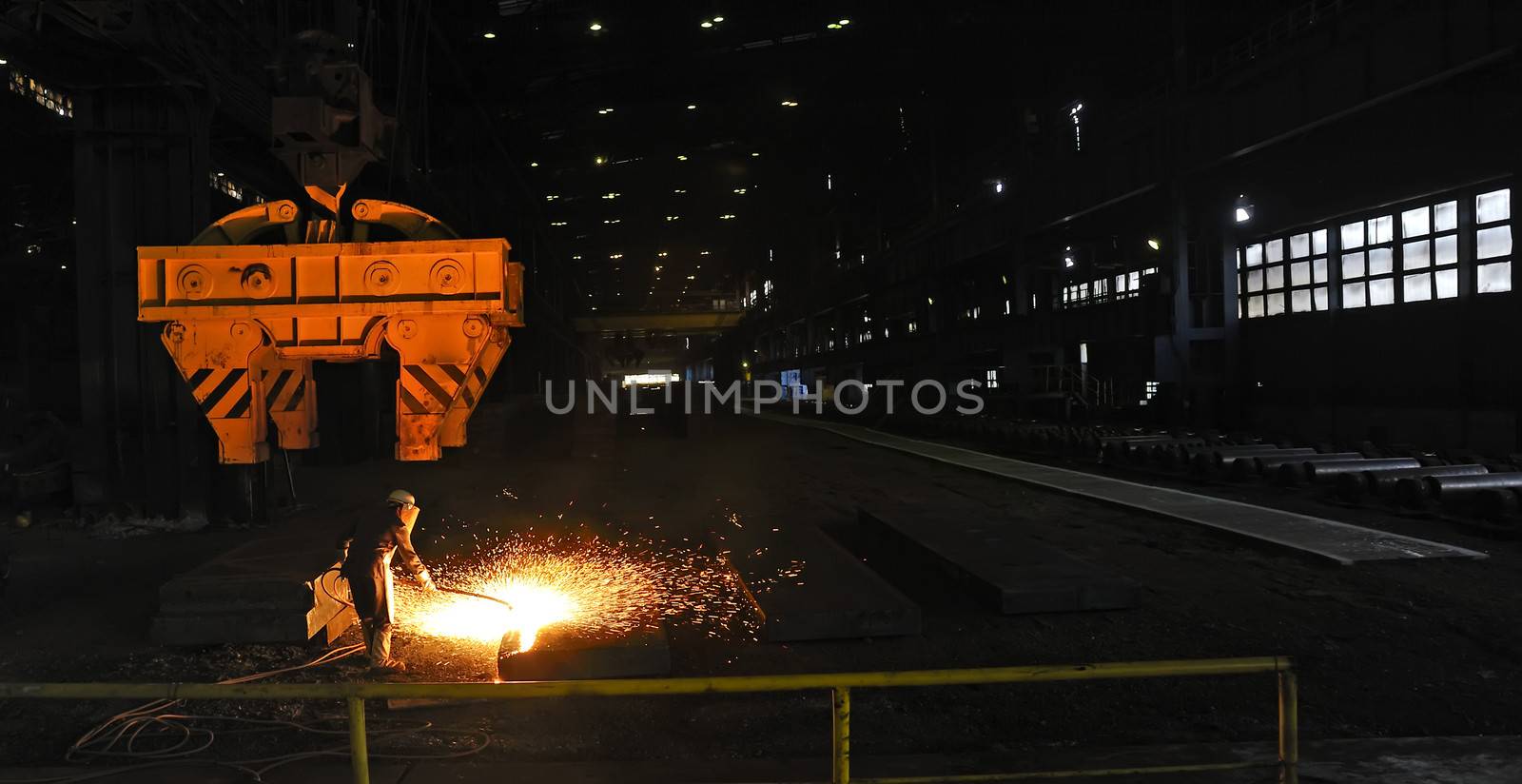 worker using torch cutter to cut through metal