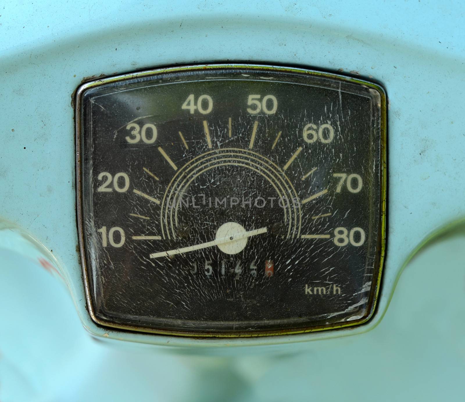 A Grungy Speedometer On A Sky Blue Scooter