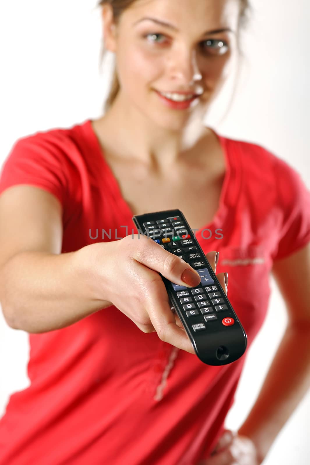 young girl watching tv using a remote control by mady70