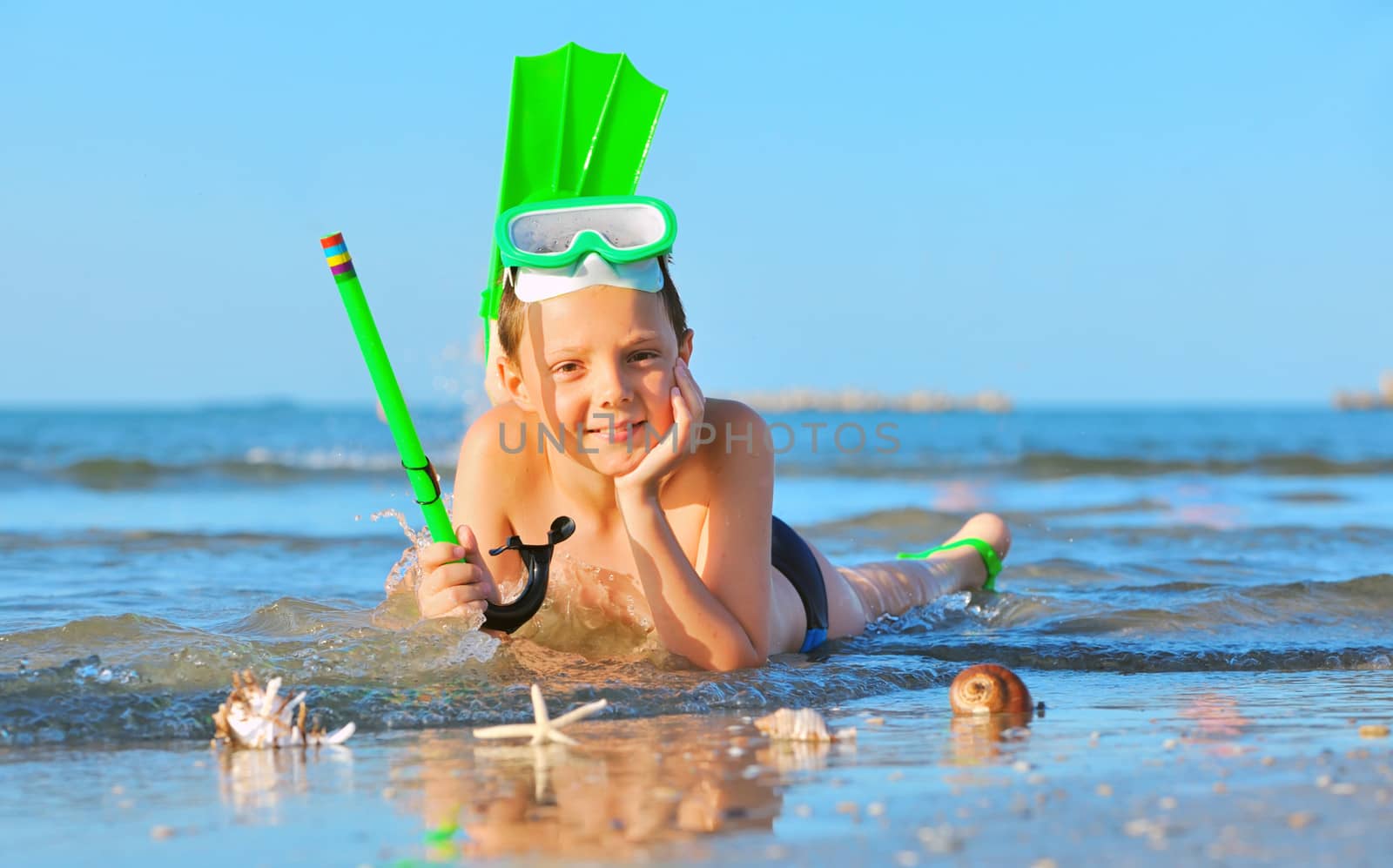 boy on beach with snorkles