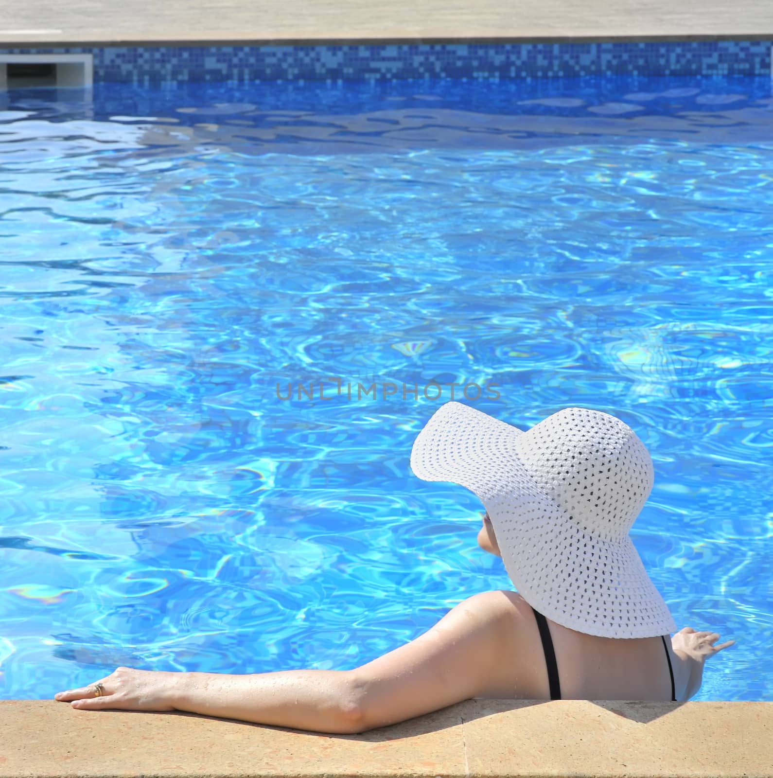 Woman sitting in a swimming pool by mady70