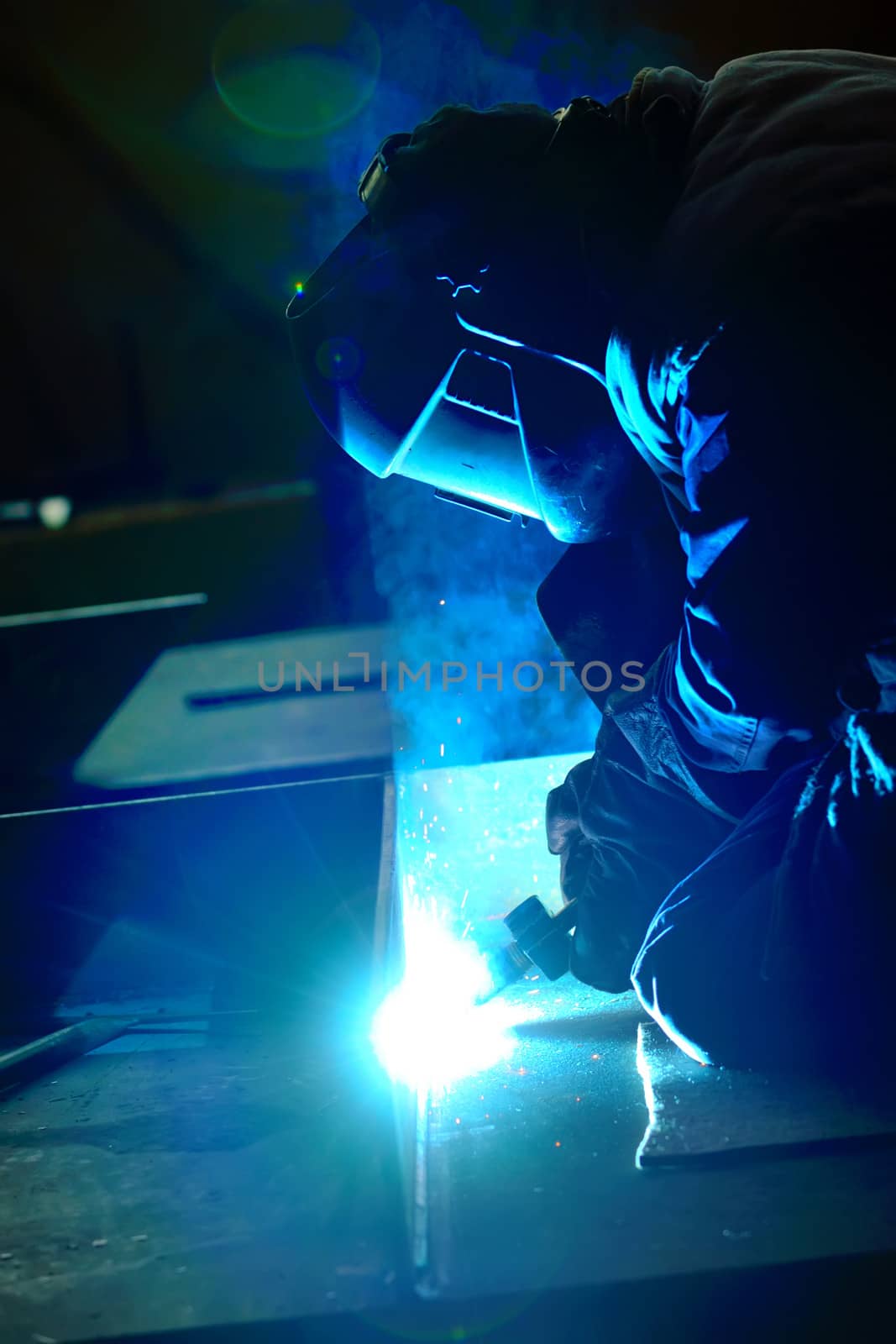 welder with protective mask welding metal and sparks