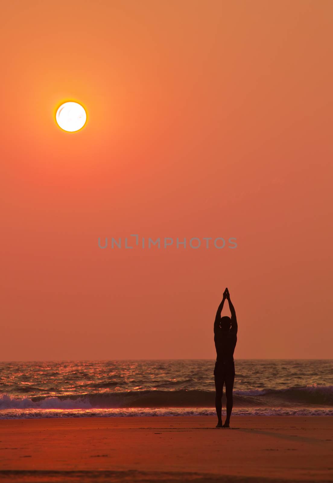 Yoga exercises at ocean sunset  Man s silhouette