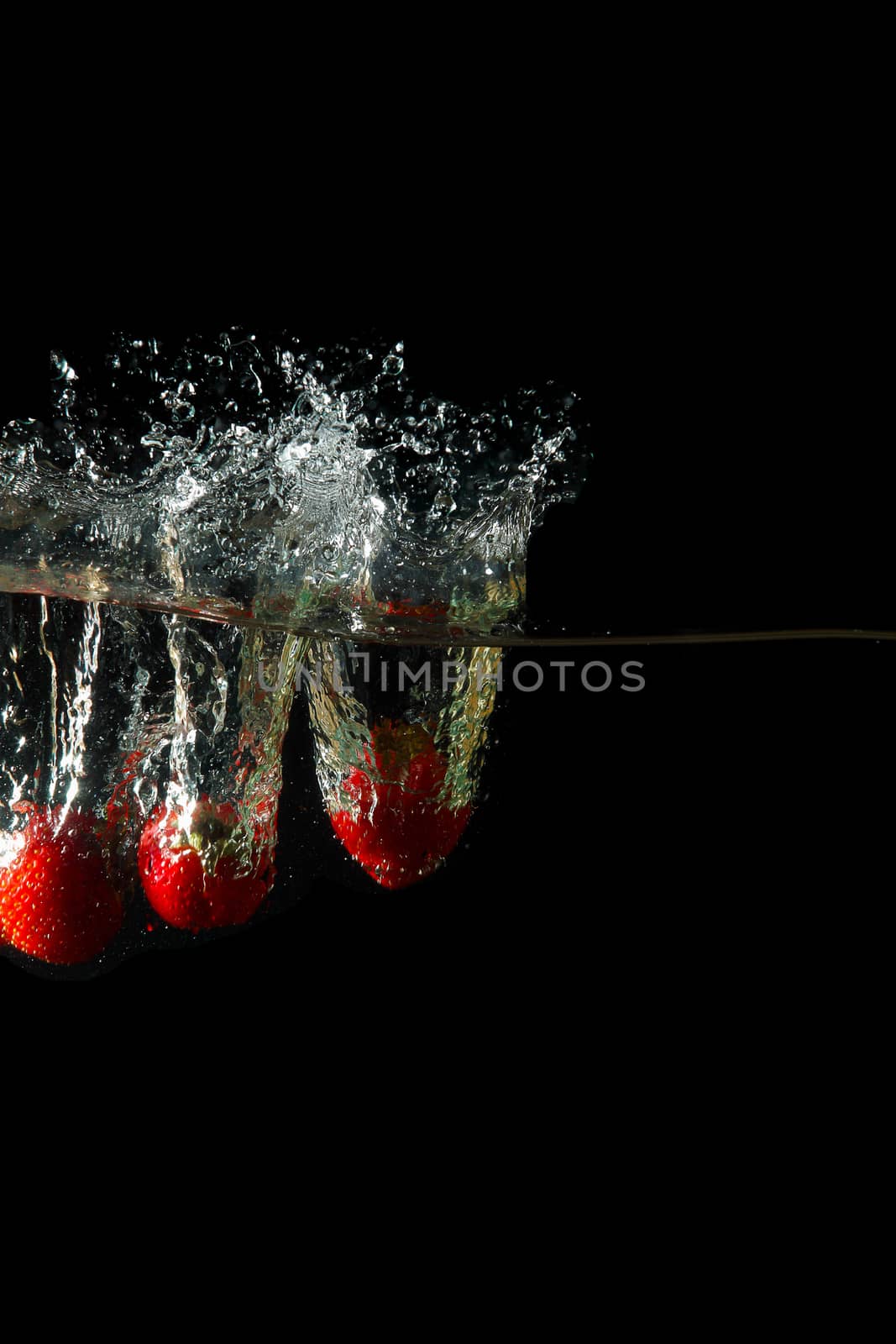 Colored red paprika in water splashes on black background