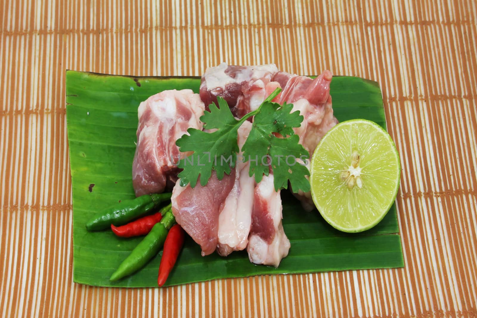 Raw pork ribs on a cutting board and vegetables by sutipp11