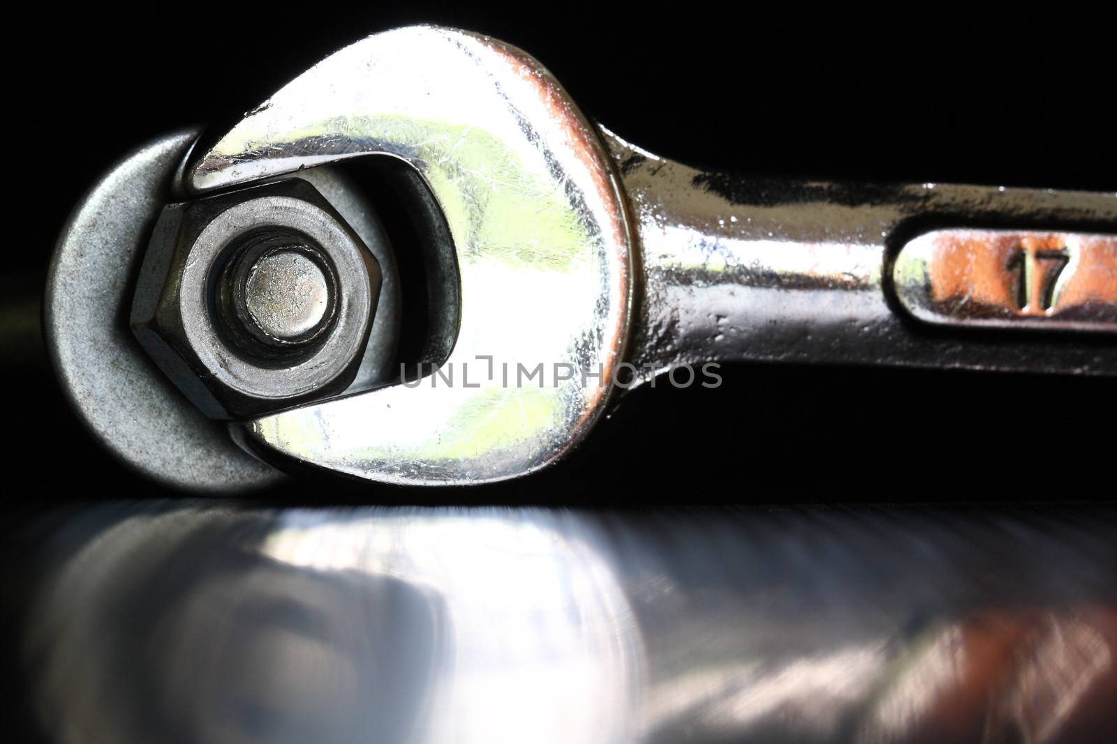 Wrench tighten the nut on black background by myrainjom01