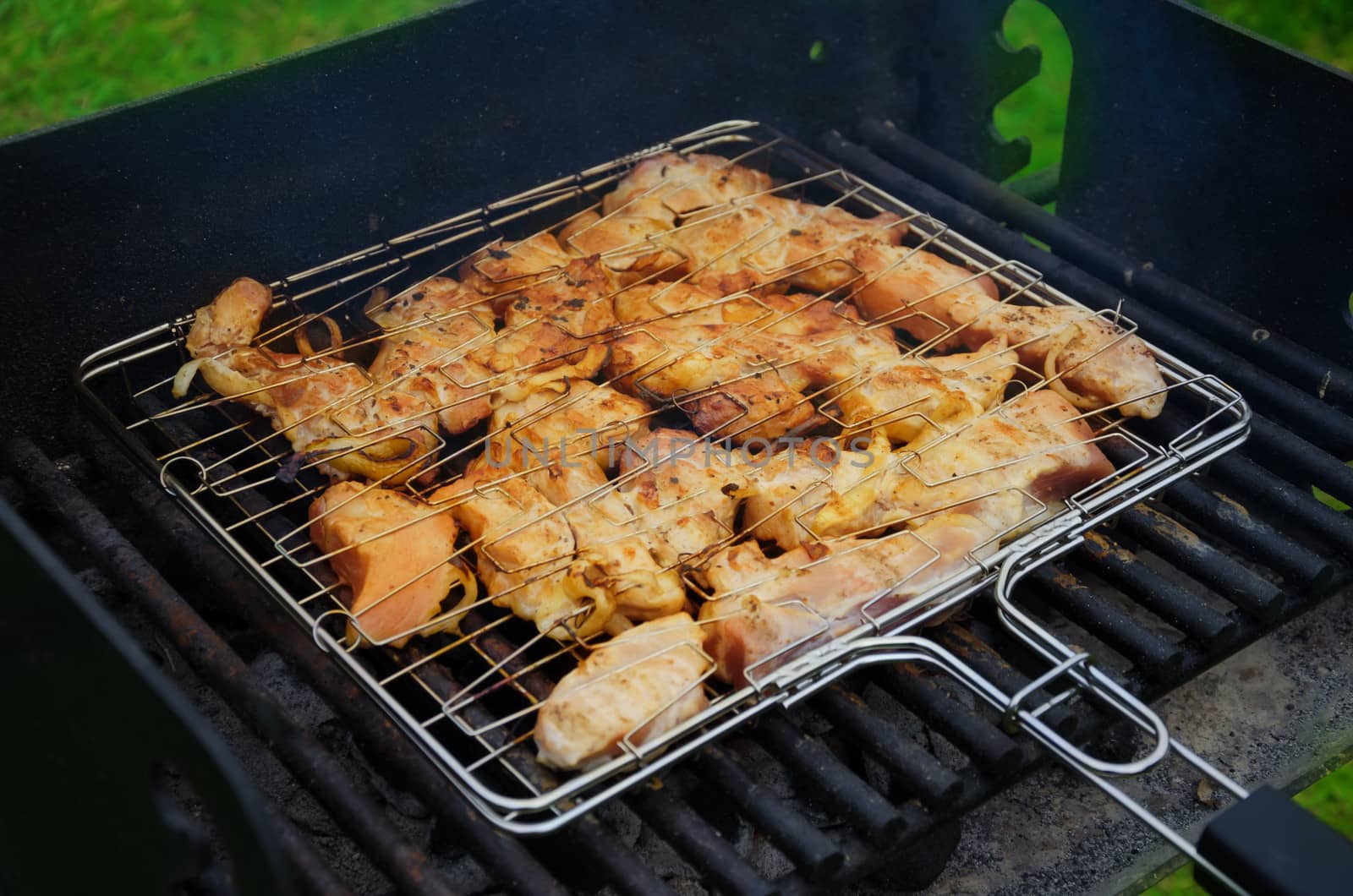 Fresh meat preparing on grill in summer day