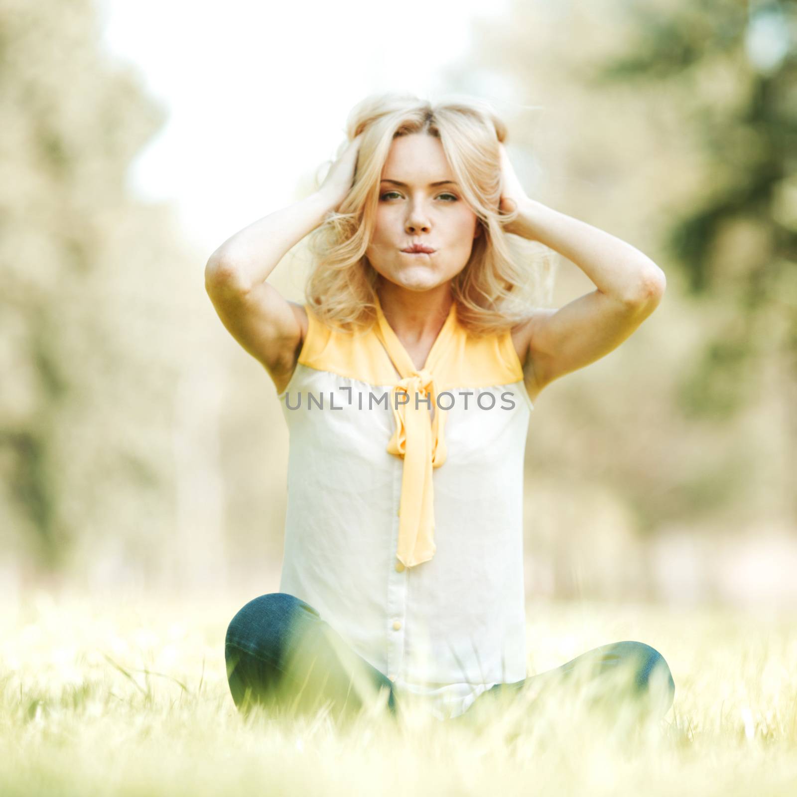 Beautiful happy young woman sitting on grass
