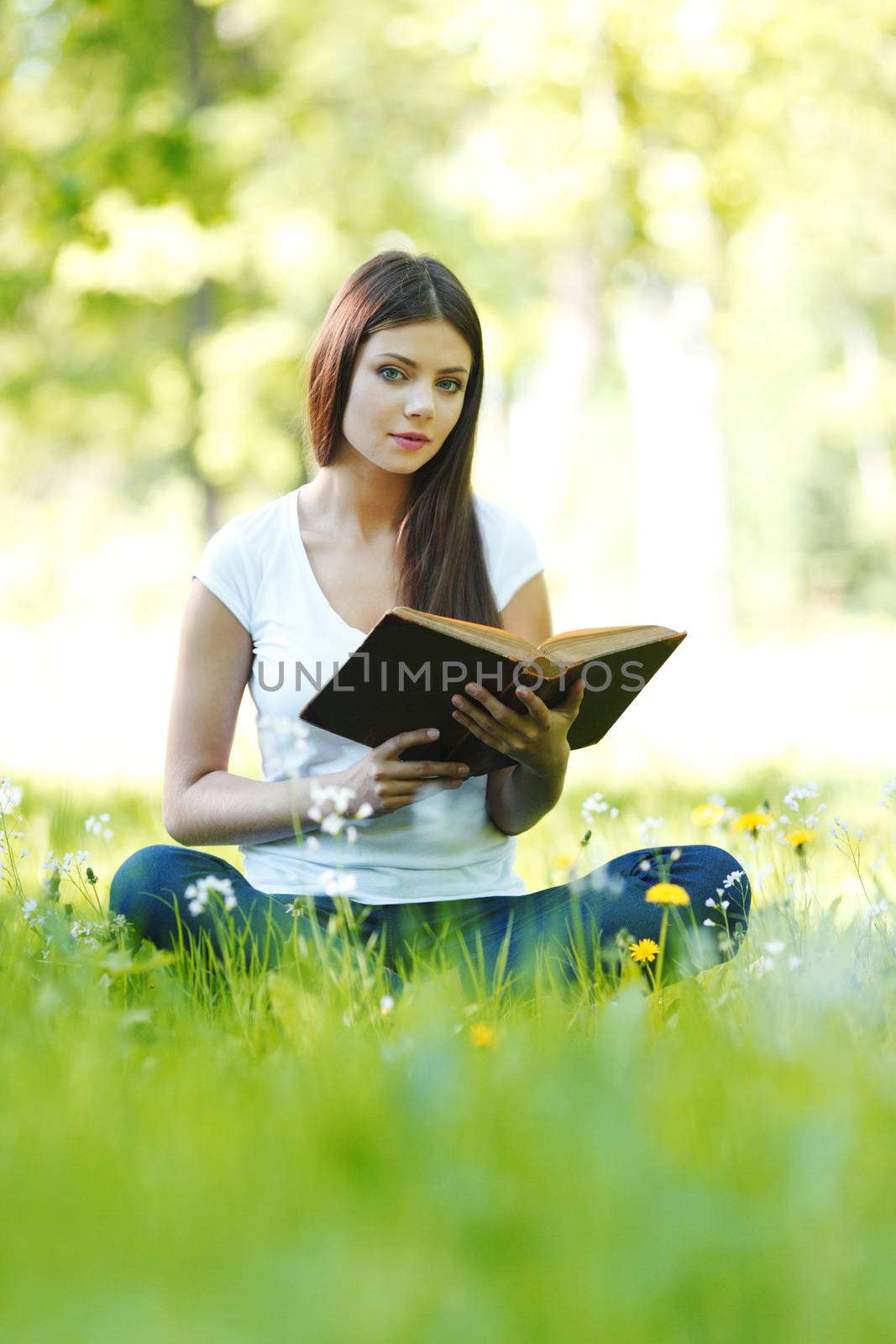 Woman reading book outdoors by Yellowj