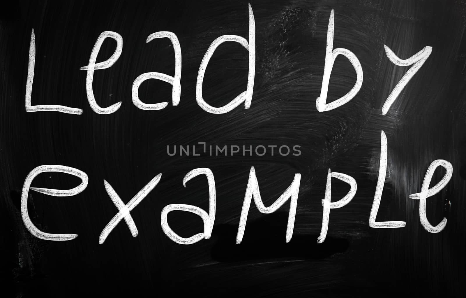 "Lead by example" handwritten with white chalk on a blackboard