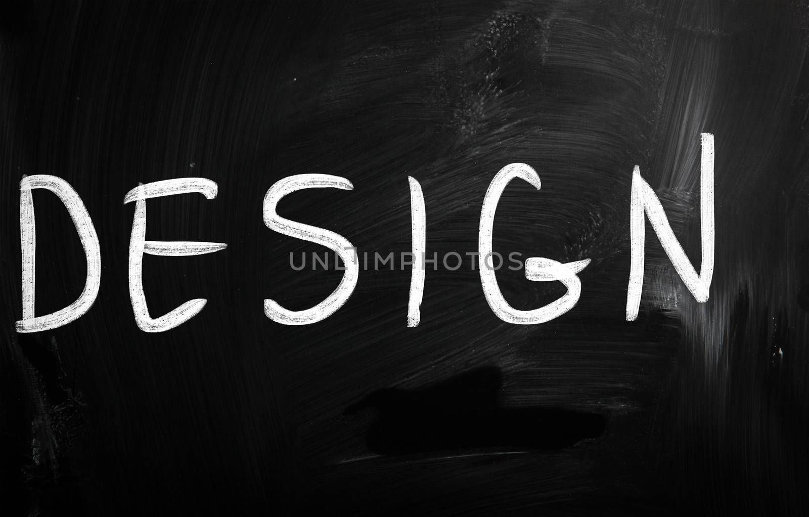 The word "Design" handwritten with white chalk on a blackboard