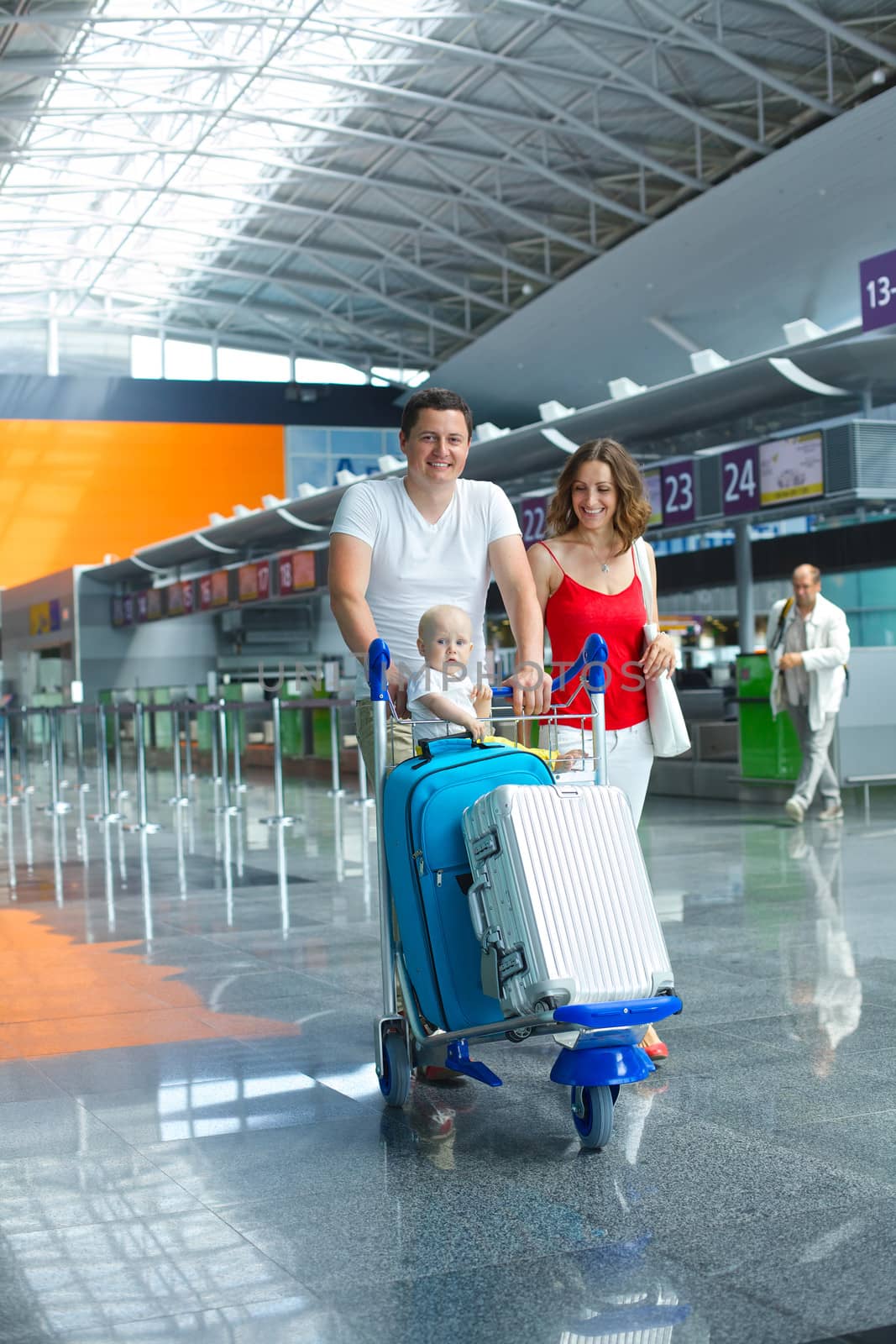 Standing traveling family with suitcases in airport