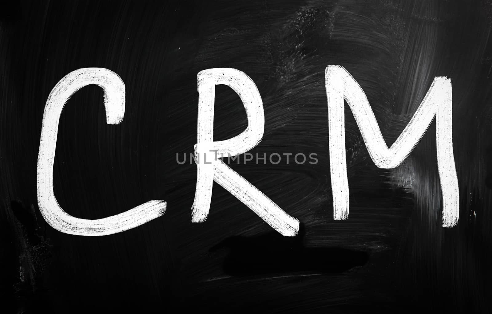The word "CRM" handwritten with white chalk on a blackboard