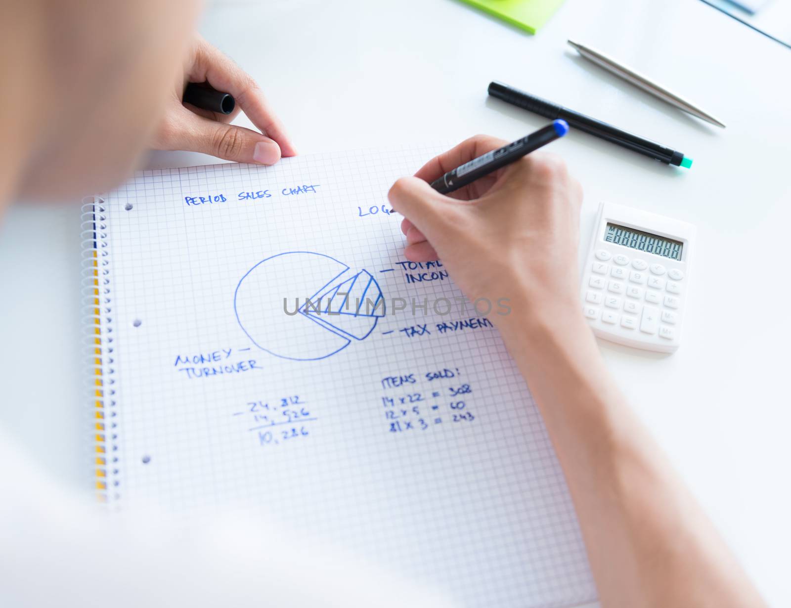Person sitting at the desk, calculating sales earnings and drawing circular diagram with numbers